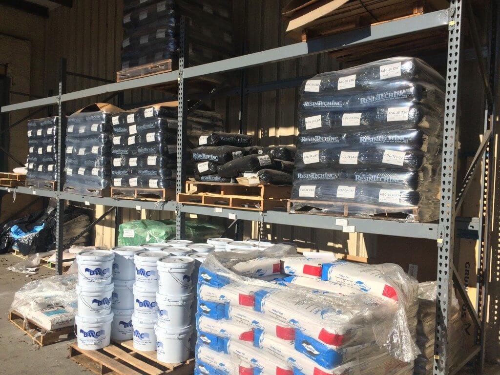 Water treatment resins loaded on shelves in warehouse.