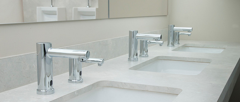 Moen's M-Power Faucets shown in a commercial bathroom.